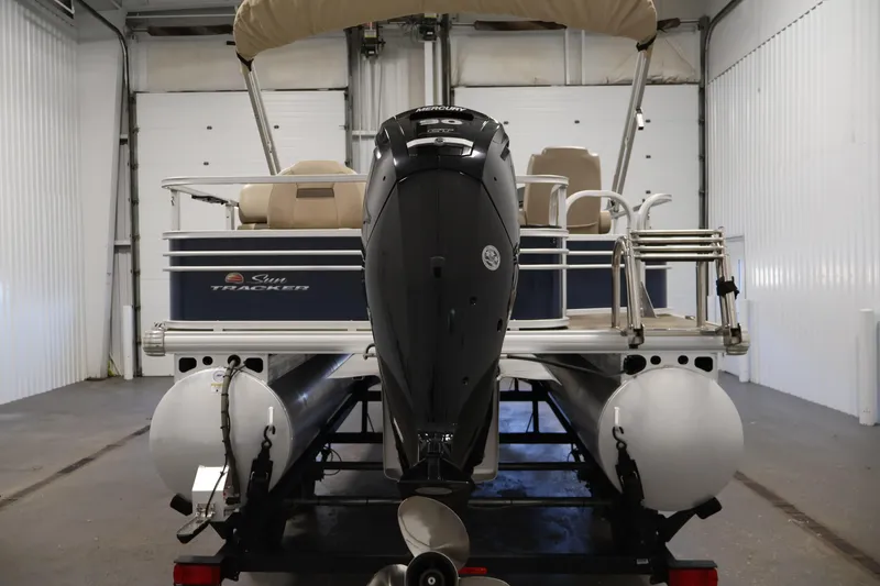 Slide: The Image of 2023 Sun Tracker Fishin' Barge 20 DLX pontoon boat in a garage setting. - 6