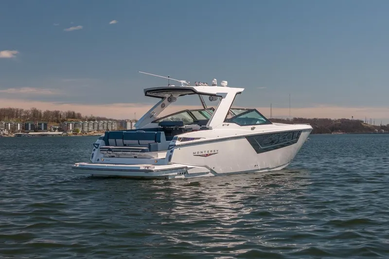 Slide: The Image of 2026 Monterey 378SS Super Sport boat on a calm lake under a clear sky. - 14