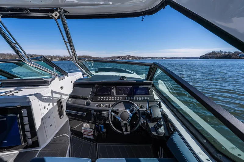 Slide: The Image of 2026 Monterey 378SS Super Sport boat cockpit with modern controls on a scenic lake. - 28