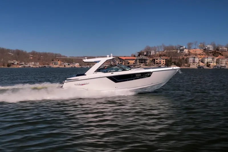 Slide: The Image of 2026 Monterey 378SS Super Sport boat cruising on a lake with scenic shoreline. - 52