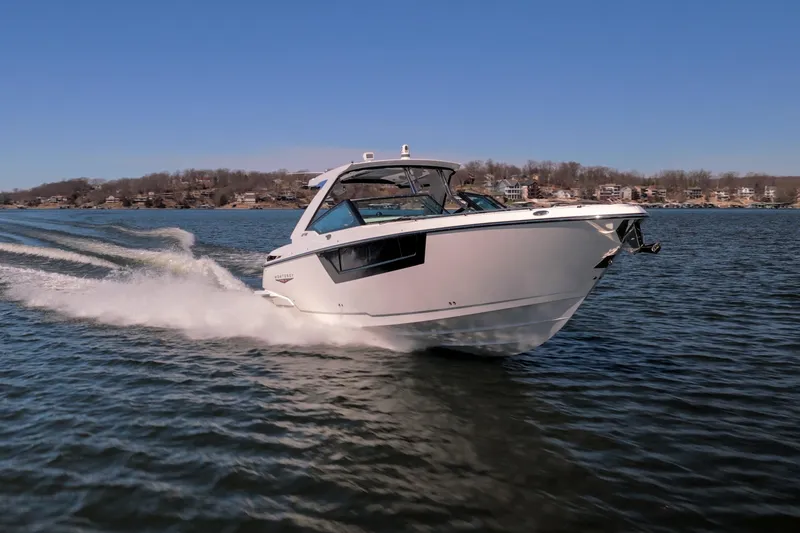 Slide: The Image of 2026 Monterey 378SS Super Sport boat cruising on a lake under clear blue skies. - 53