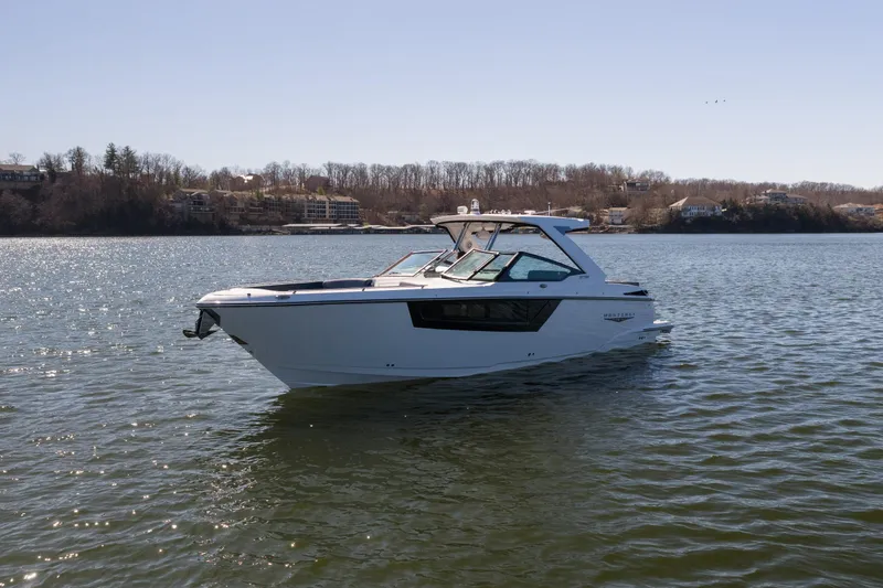 Slide: The Image of 2026 Monterey 378SS Super Sport boat on a serene lake with wooded shoreline. - 62