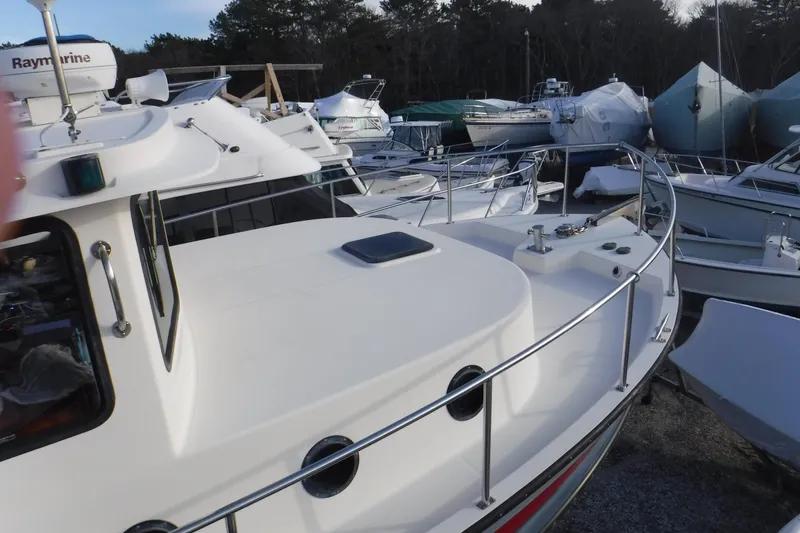 Slide: The Image of Nordic Tug 37 (2002) docked among other boats, showcasing its deck and railing. - 11