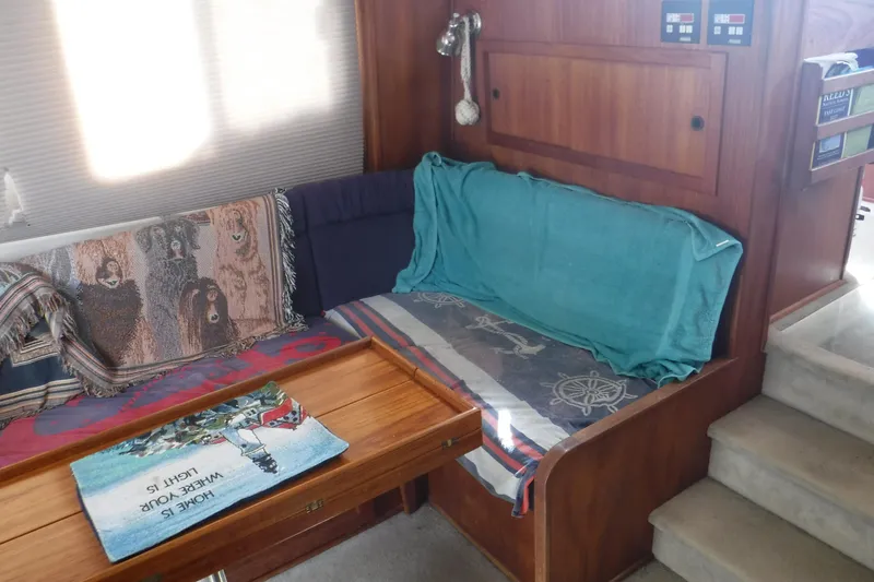 Slide: The Image of Cozy interior of a 2002 Nordic Tug 37 with wooden table and patterned cushions. - 16