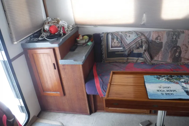 Slide: The Image of Cozy interior of a 2002 Nordic Tug 37 with wooden cabinetry and a cushioned seating area. - 17