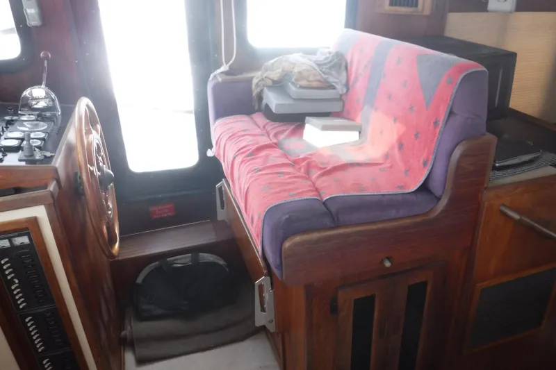 Slide: The Image of Cozy interior of a 2002 Nordic Tug 37 with a cushioned seat and nautical controls. - 26