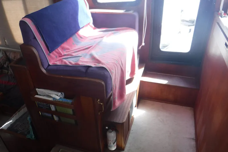 Slide: The Image of Interior of a 2002 Nordic Tug 37 with a covered seat and wooden paneling. - 27