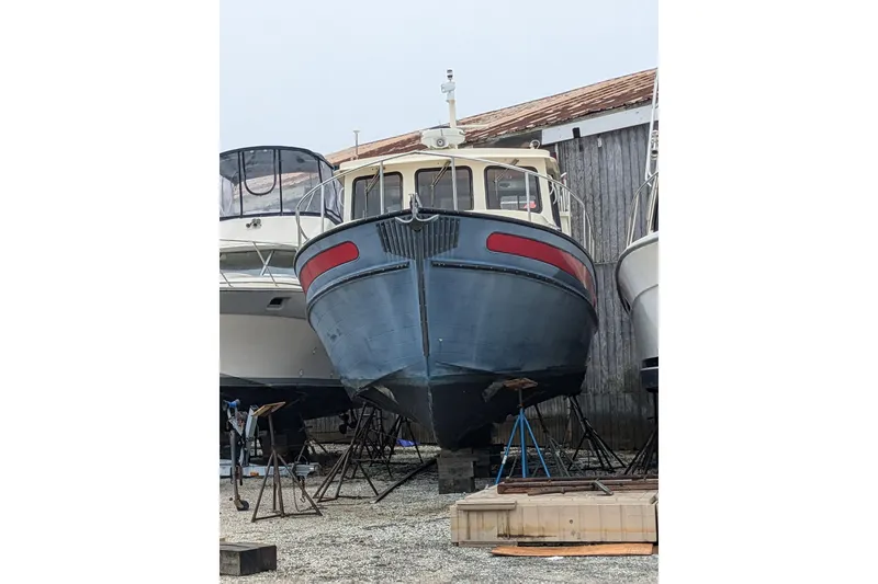 Slide: The Image of 2002 Nordic Tug 37 boat on dry dock, surrounded by other vessels. - 3