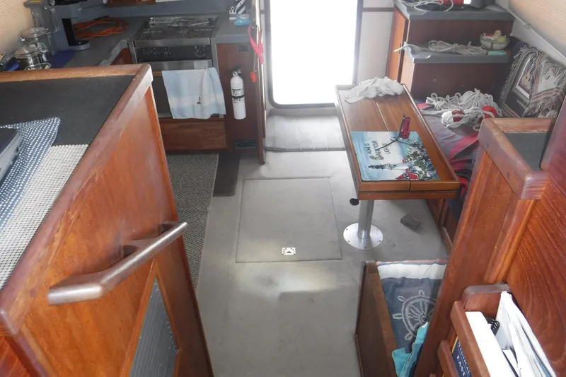 Slide: The Image of Interior of a 2002 Nordic Tug 37, featuring a cozy dining area and kitchen. - 34