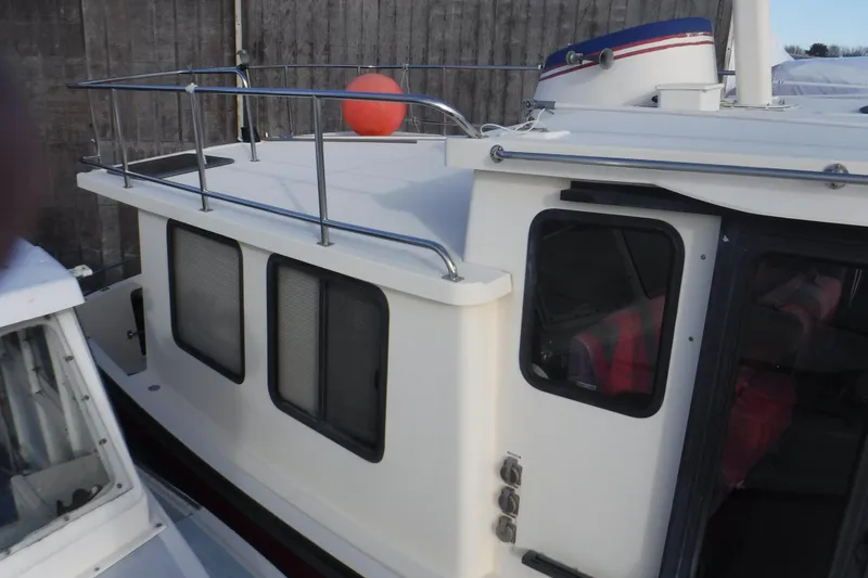 Slide: The Image of Nordic Tug 37, 2002 model, featuring a white cabin with metal railings and windows. - 5