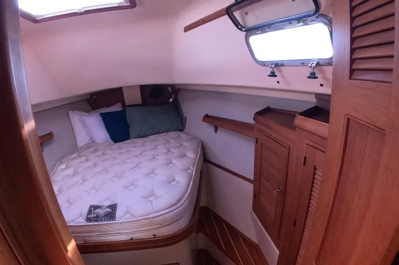 Slide: The Image of Cozy cabin interior of 2005 Island Packet 370 sailboat with bed and wooden storage. - 9