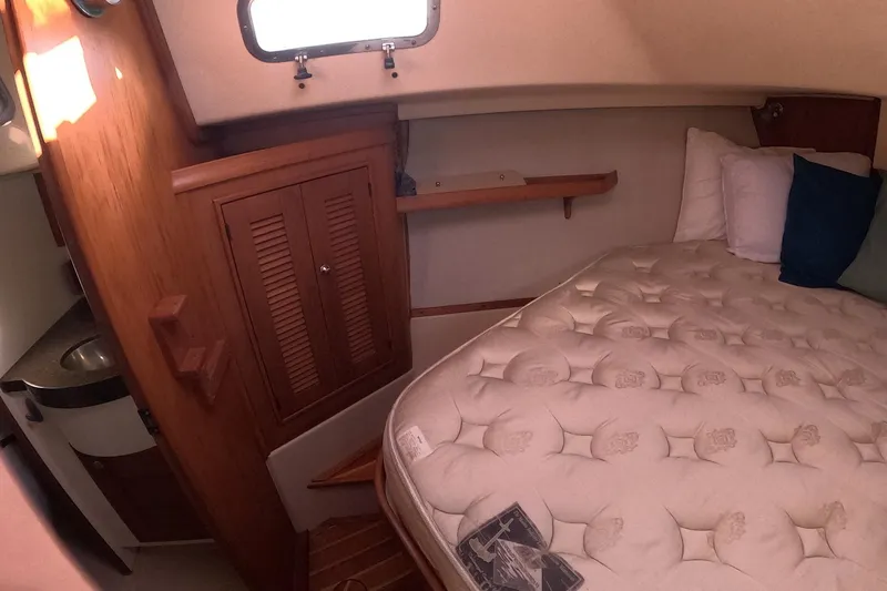 Slide: The Image of Cozy cabin interior of 2005 Island Packet 370 sailboat with bed and wooden cabinetry. - 7