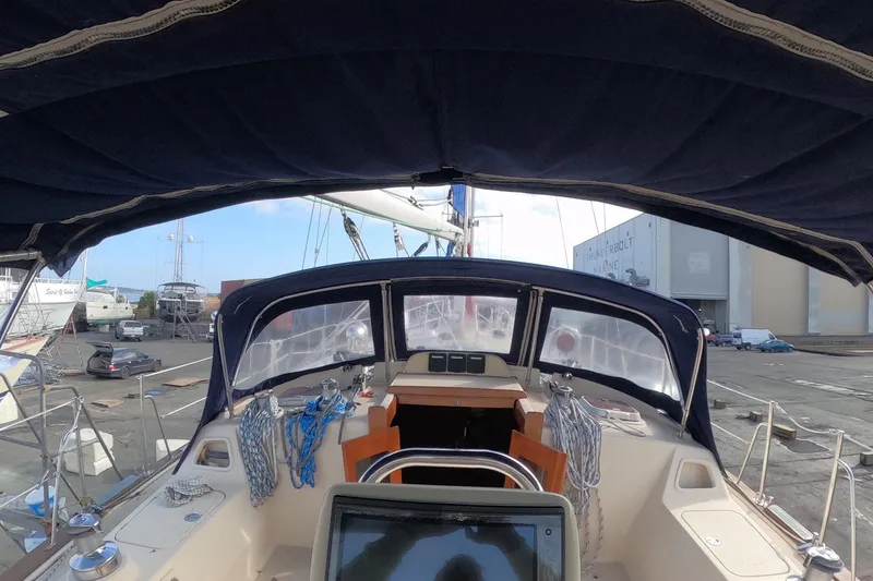 Slide: The Image of 2005 Island Packet 370 sailboat cockpit view at marina, featuring navigation equipment and ropes. - 24