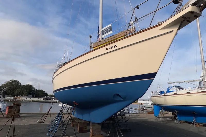 Slide: The Image of 2005 Island Packet 370 sailboat on dry dock, showcasing hull and marina background. - 36