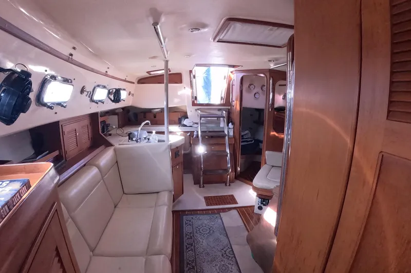 Slide: The Image of Interior of 2005 Island Packet 370 sailboat with cozy seating and wooden finishes. - 10