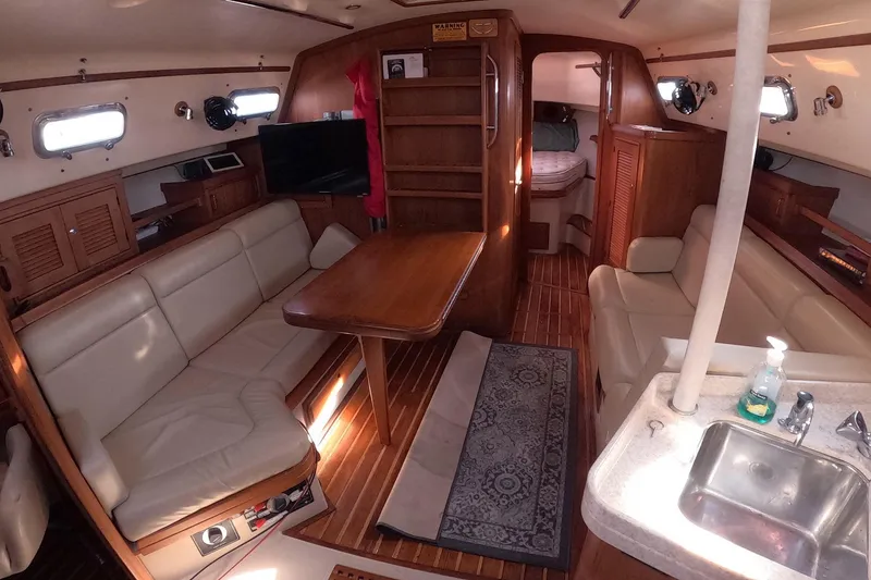 Slide: The Image of Interior of 2005 Island Packet 370 sailboat with cozy seating and wooden finishes. - 4