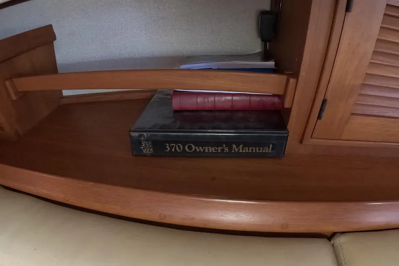 Slide: The Image of Owner's manual for 2005 Island Packet 370 sailboat on wooden shelf. - 17