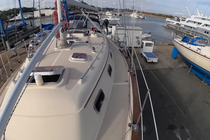 Slide: The Image of 2005 Island Packet 370 sailboat docked at a marina, showcasing deck and rigging. - 31