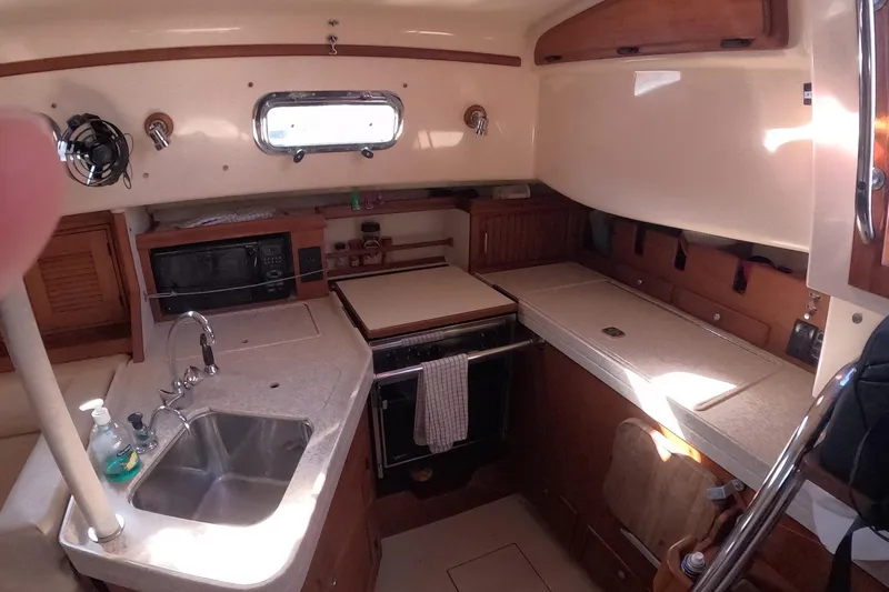Slide: The Image of Interior of 2005 Island Packet 370 sailboat kitchen with sink, stove, and storage. - 11