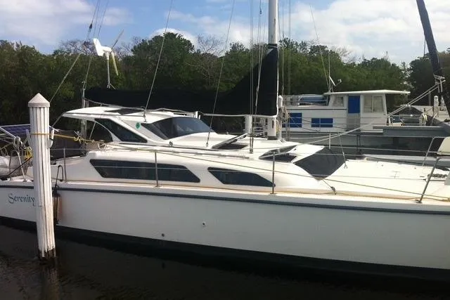 The Image of 2005 Gemini MC 105 catamaran docked at marina with lush greenery background. - 0