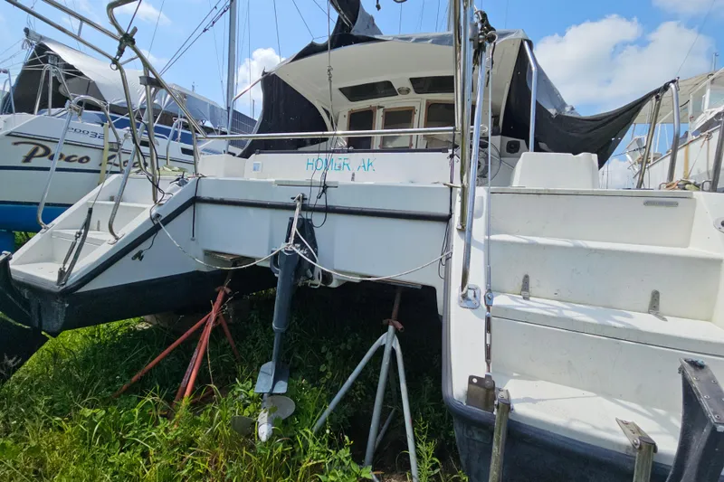 Slide: The Image of Catamaran Gemini MC 105, 2005 model, on land with support stands, under a clear sky. - 13
