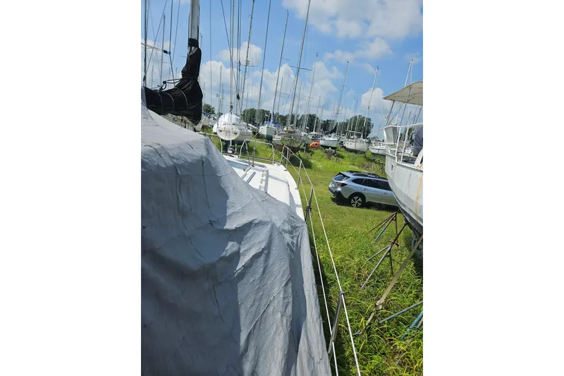 Slide: The Image of Boats in a grassy yard, featuring a covered Gemini MC 105, 2005 model. - 14