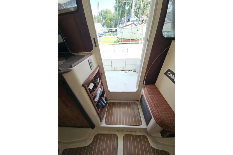 Slide: The Image of Interior view of a 2005 Gemini MC 105 boat, featuring wooden flooring and seating. - 15