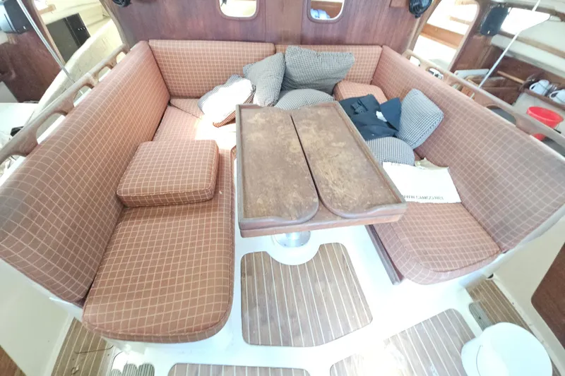 Slide: The Image of Interior of 2005 Gemini MC 105 sailboat with cushioned seating and wooden table. - 18
