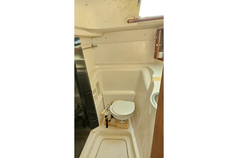 Slide: The Image of Compact bathroom in 2005 Gemini MC 105 boat, featuring a toilet and sink. - 24