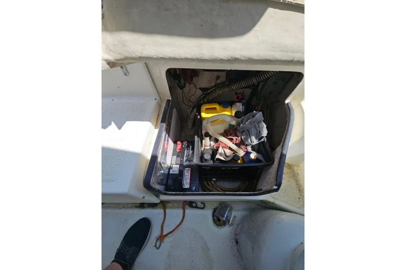 Slide: The Image of Open storage compartment on 2005 Gemini MC 105 boat with various maintenance supplies. - 29