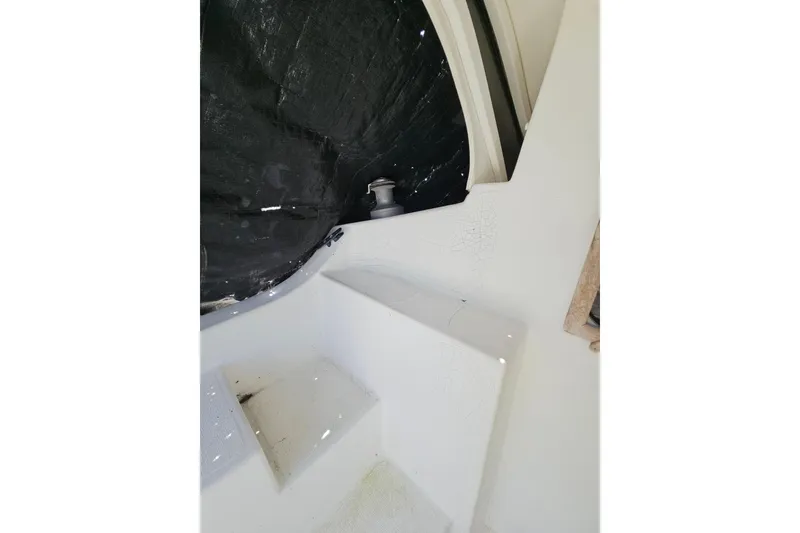 Slide: The Image of Interior view of a 2005 Gemini MC 105 boat, featuring white steps and a black tarp. - 30