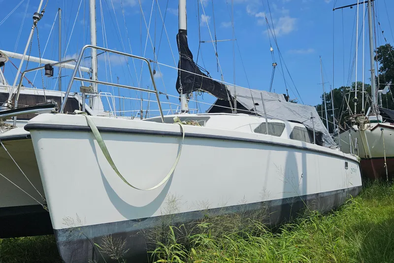 Slide: The Image of 2005 Gemini MC 105 sailboat on land, surrounded by grass and other boats. - 5