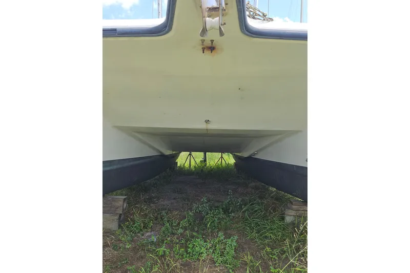 Slide: The Image of Underneath view of a 2005 Gemini MC 105 catamaran on grassy land. - 6