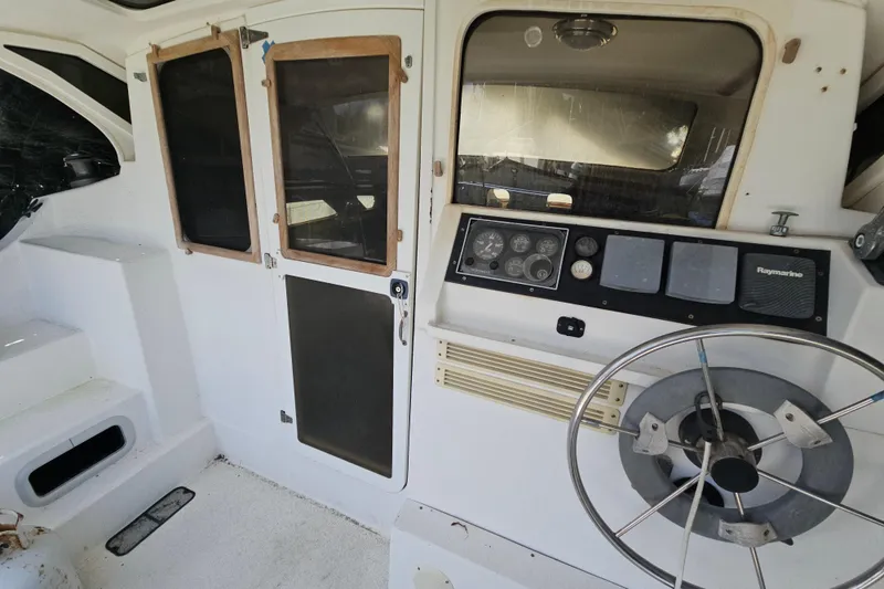 Slide: The Image of Interior of a 2005 Gemini MC 105 boat cockpit with steering wheel and control panel. - 8