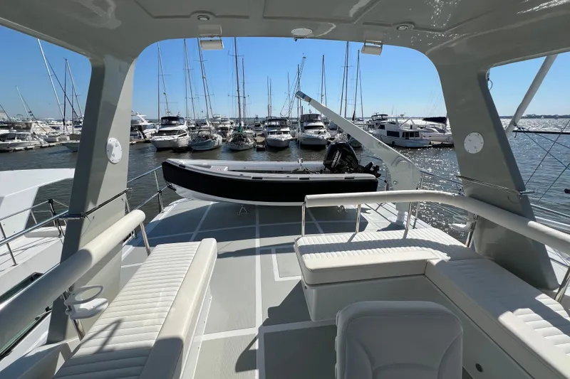 Slide: The Image of 2025 Helmsman Trawlers 43E PILOTHOUSE yacht deck with seating, docked at marina. - 4