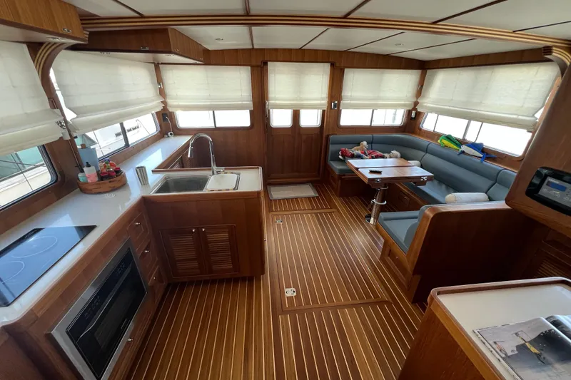 Slide: The Image of Luxurious interior of 2025 Helmsman Trawlers 43E Pilothouse with modern kitchen and seating area. - 6