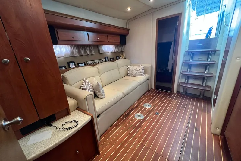Slide: The Image of Interior of 2008 Rinker 400 Express Cruiser with beige sofa and wooden flooring. - 10
