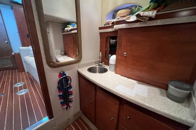 Slide: The Image of Interior of 2008 Rinker 400 Express Cruiser with wooden cabinetry and compact sink area. - 12