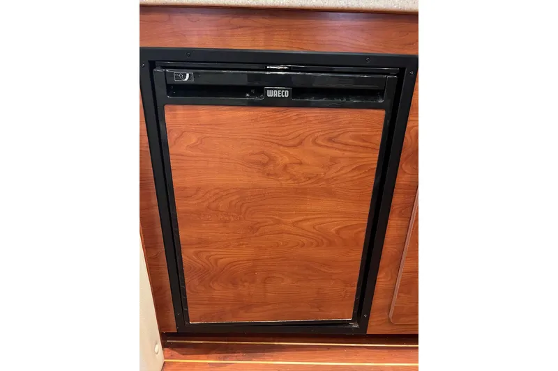 Slide: The Image of Wood-paneled WAECO fridge in 2008 Rinker 400 Express Cruiser kitchen. - 13