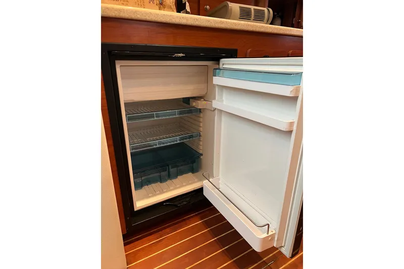 Slide: The Image of Open refrigerator inside 2008 Rinker 400 Express Cruiser, showcasing interior shelves and storage. - 14