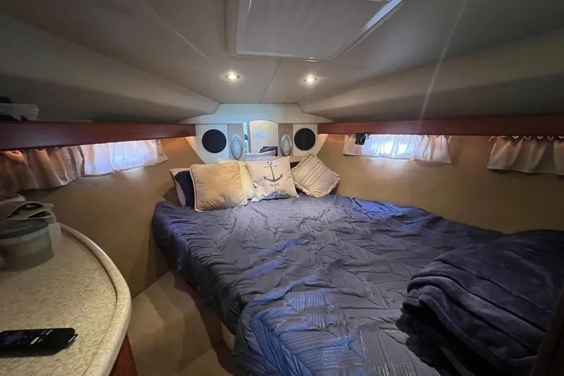 Slide: The Image of Cozy cabin interior of 2008 Rinker 400 Express Cruiser with bed and soft lighting. - 15