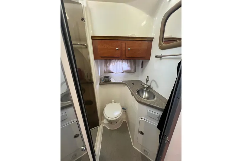 Slide: The Image of 2008 Rinker 400 Express Cruiser bathroom with sink, toilet, and storage cabinets. - 16