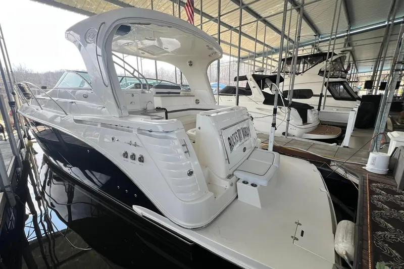 Slide: The Image of 2008 Rinker 400 Express Cruiser docked in a marina, showcasing sleek design and spacious deck. - 2