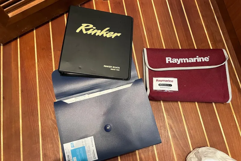 Slide: The Image of Rinker 400 Express Cruiser 2008 manuals and Raymarine pouch on wooden floor. - 20