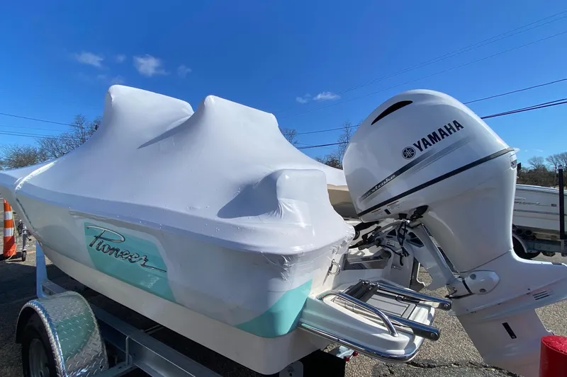 Slide: The Image of 2026 Pioneer 180 Sportfish boat with Yamaha outboard motor, covered and on trailer. - 3