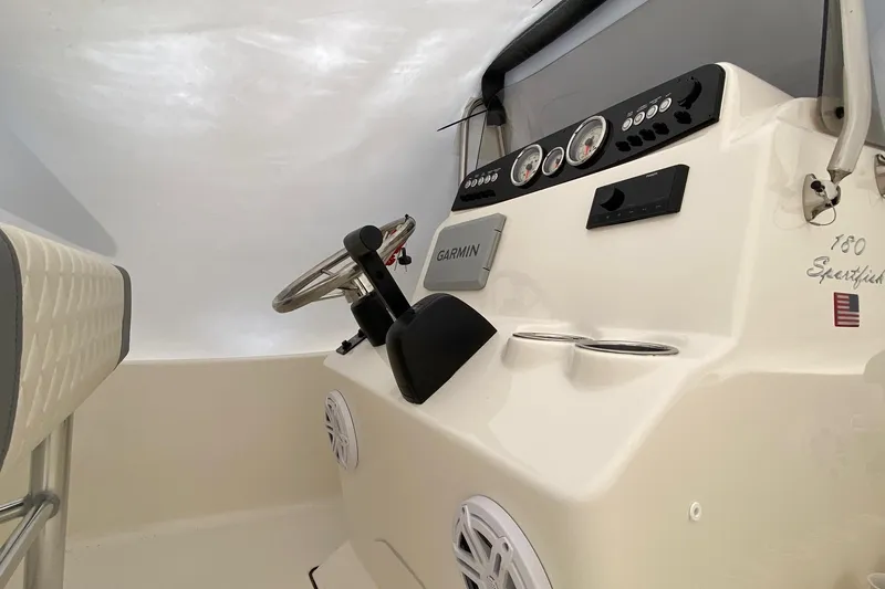 Slide: The Image of 2026 Pioneer 180 Sportfish boat dashboard with Garmin navigation and steering wheel. - 6