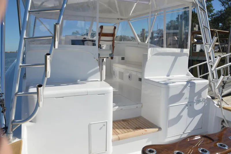 Slide: The Image of 2006 Custom Carolina Heritage Express boat interior with seating and ladder, docked by the water. - 14