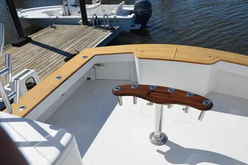 Slide: The Image of 2006 Custom Carolina Heritage Express boat deck with wooden trim and rod holders. - 16