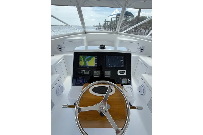 Slide: The Image of Helm of 2006 Custom Carolina Heritage Express boat with navigation screens and wooden steering wheel. - 2