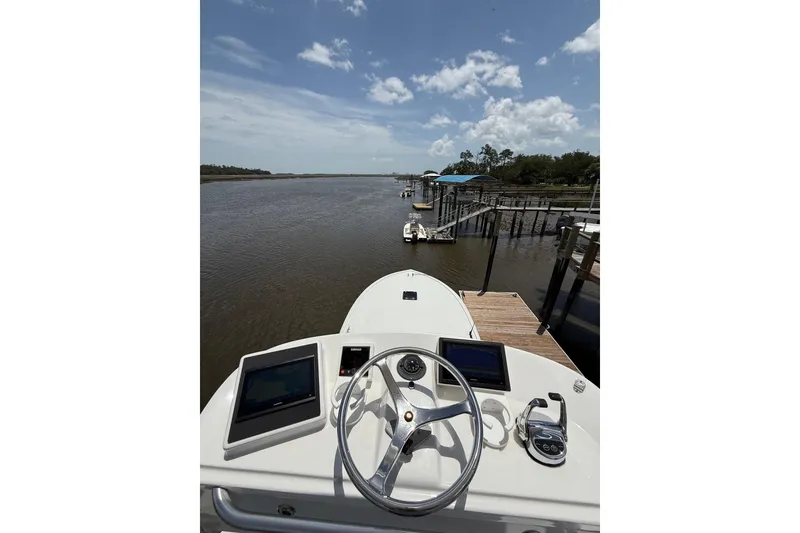Slide: The Image of 2006 Custom Carolina Heritage Express boat at dock, river view, clear sky. - 21